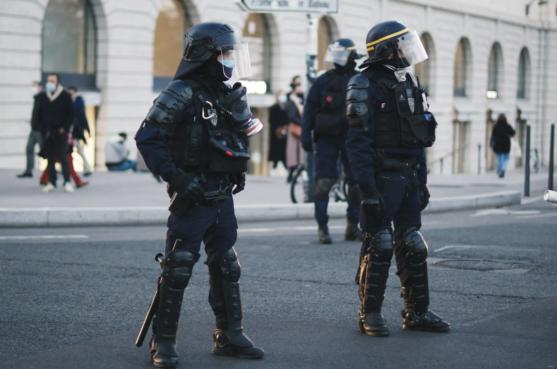 2 men in black and white helmet and black helmet walking on street during daytime